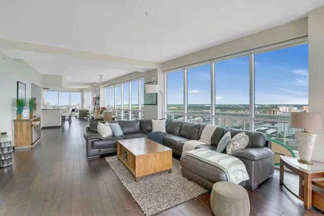 a living room with furniture wooden floor and a large window