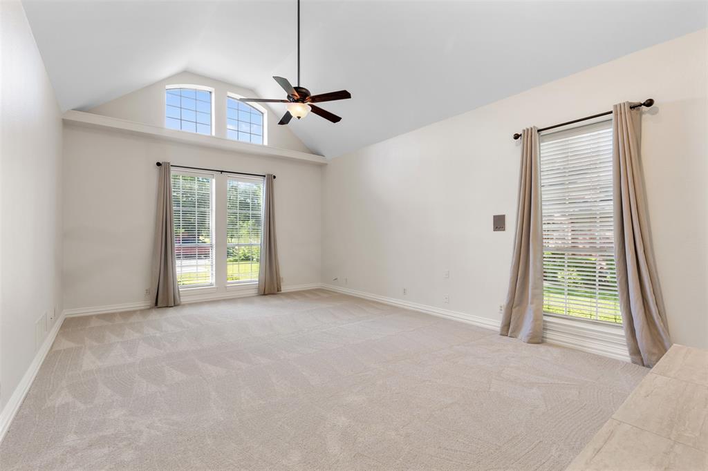 609 Seville Road Denton, TX 76205 - Photo 21 of 40 Spacious primary bedroom with light pouring in and vaulted ceilings.