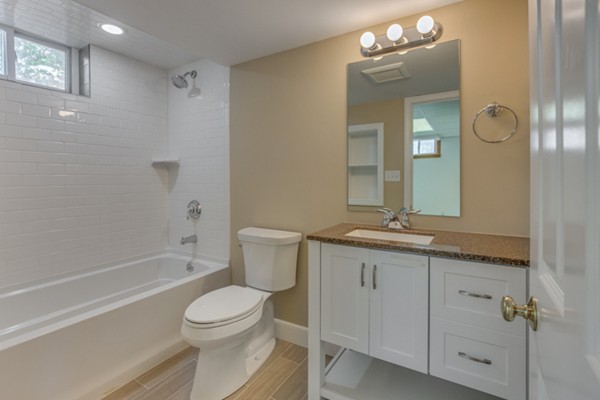 10 Janet Road Arlington, MA 02474 - Photo 22 of 26 a bathroom with a granite countertop toilet a sink and a mirror