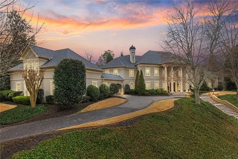 a front view of a house with yard and green space
