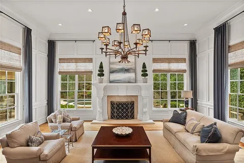 a living room with furniture a chandelier and a fireplace