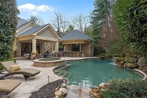 an aerial view of a house with a yard lake and outdoor seating