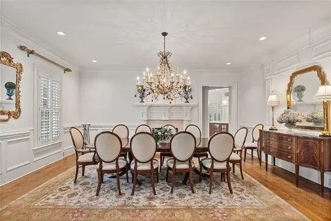 a kitchen with a stove a sink a refrigerator and chairs