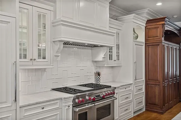 a large kitchen with stainless steel appliances lots of counter space and wooden floor