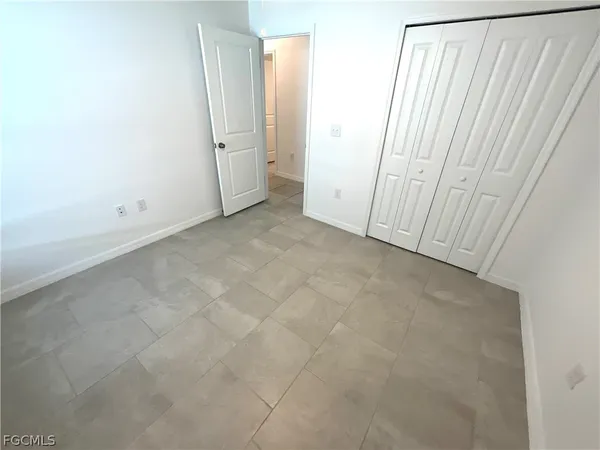 an empty room with a white checkered floor and fan