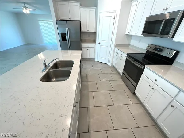 a kitchen with a refrigerator and a stove top oven