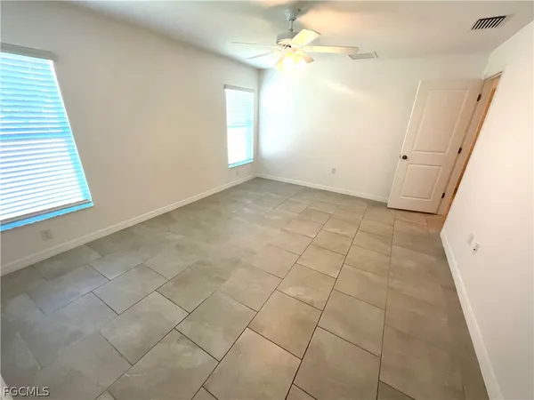 en empty room with windows and fan