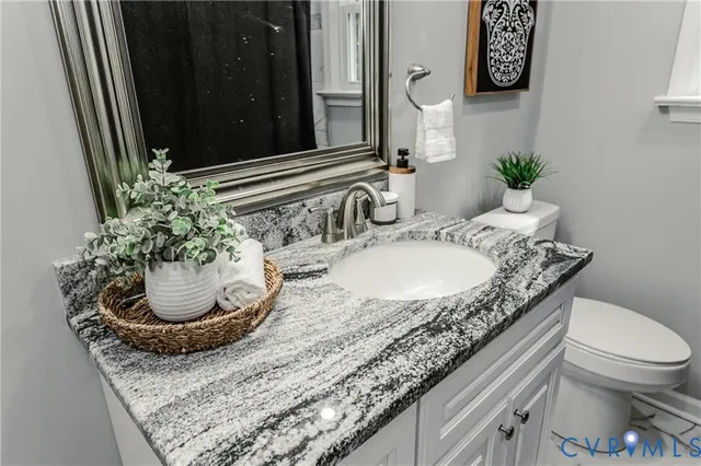 a bathroom with a granite countertop sink and a mirror