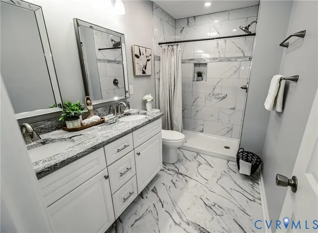 a bathroom with a granite countertop sink toilet and shower