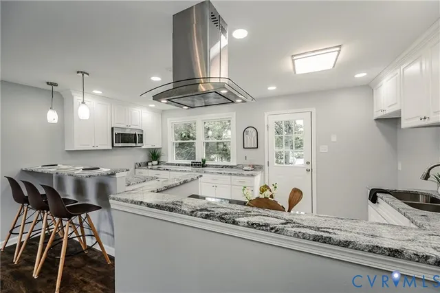 a large kitchen with kitchen island a stove a sink a center island a stove a cabinets and a dining table