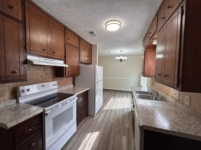 a kitchen with stainless steel appliances granite countertop a sink stove and cabinets