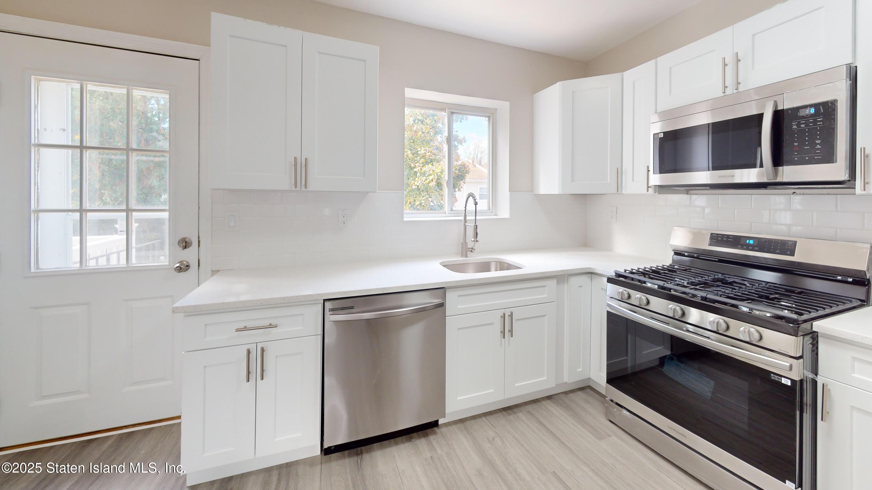 109 Lyceum Court Staten Island, NY 10310 - Photo 13 of 32 a kitchen with cabinets stainless steel appliances a sink and a window