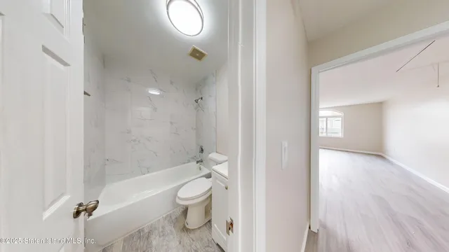 a bathroom with a granite countertop toilet a sink and a mirror