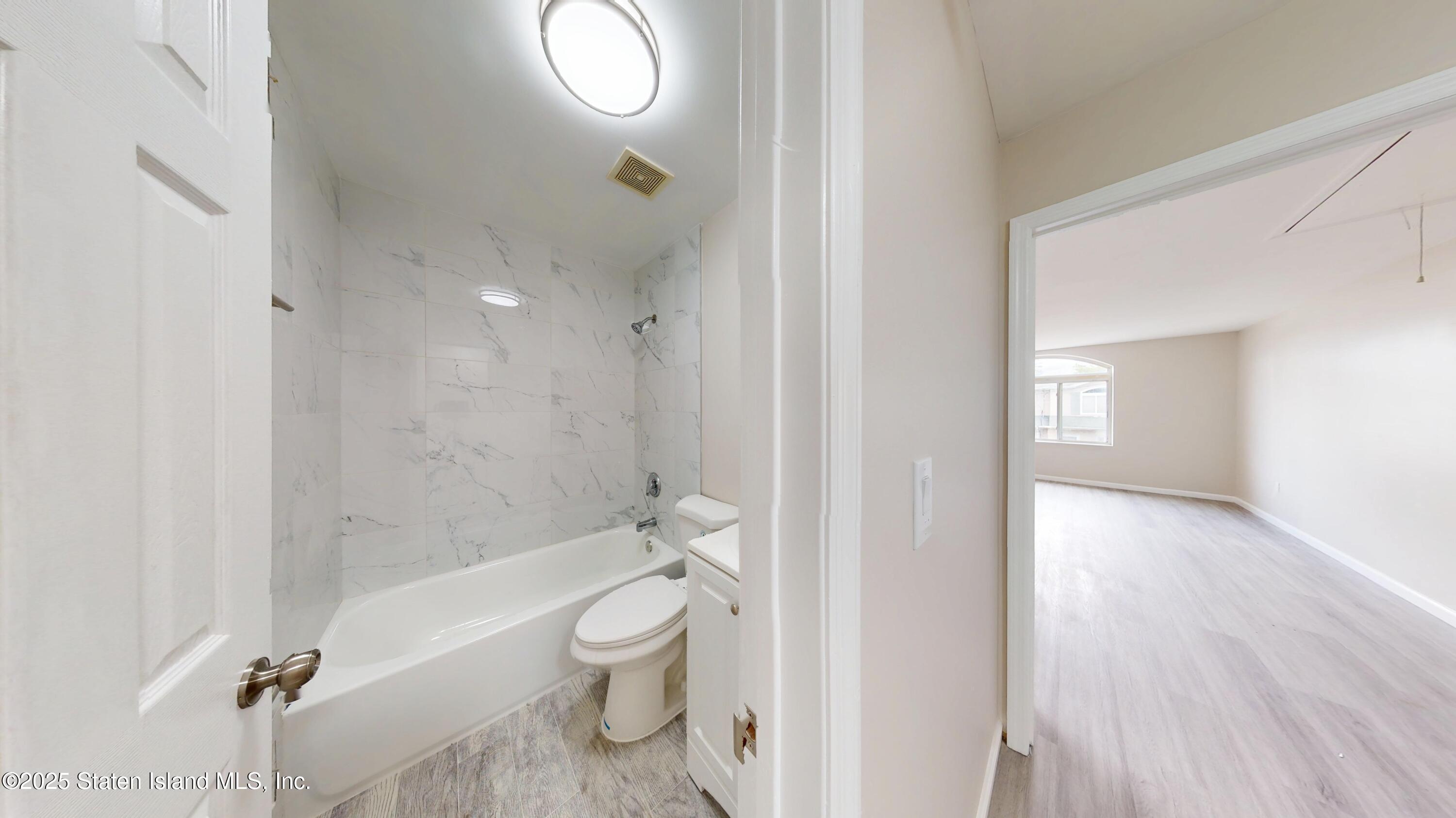 109 Lyceum Court Staten Island, NY 10310 - Photo 19 of 32 a bathroom with a granite countertop toilet a sink and a mirror