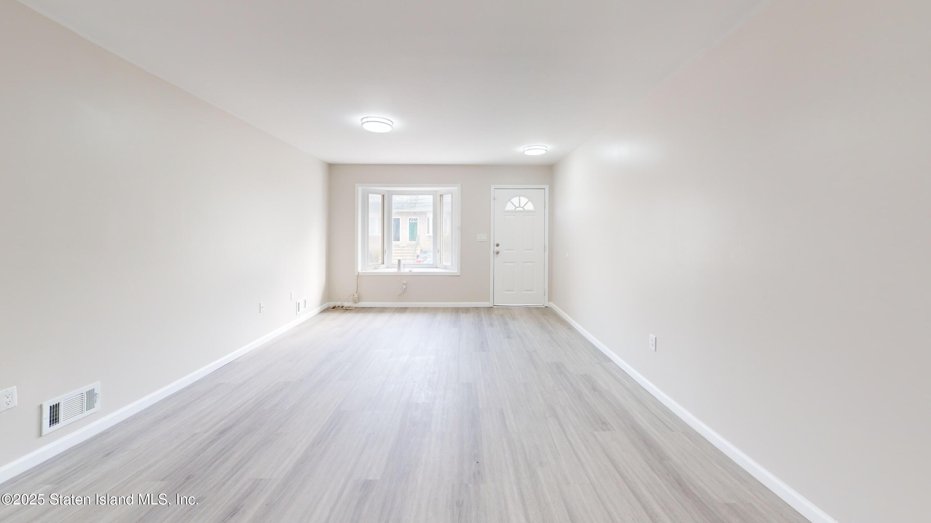 109 Lyceum Court Staten Island, NY 10310 - Photo 23 of 32 an empty room with wooden floor and windows