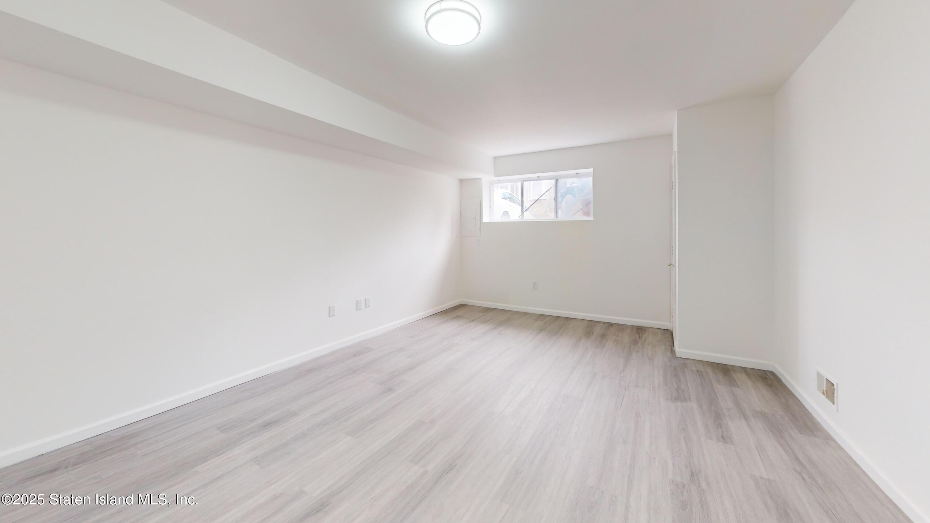 109 Lyceum Court Staten Island, NY 10310 - Photo 24 of 32 an empty room with wooden floor and windows