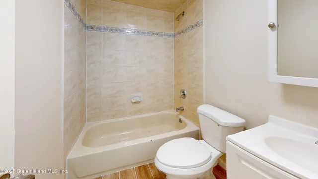 a white toilet sitting next to a bath tub