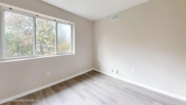 a view of a room with wooden floor and windows