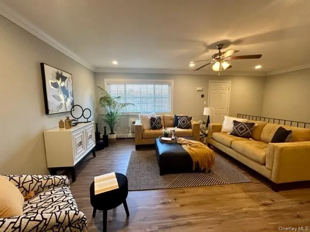 a living room with furniture kitchen view and a window