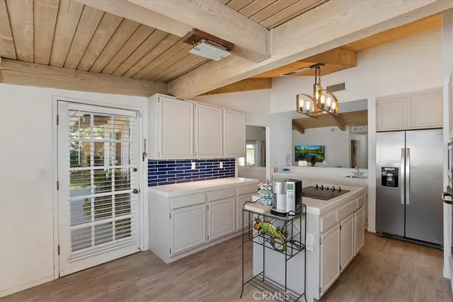 a kitchen with kitchen island granite countertop a sink cabinets and stainless steel appliances