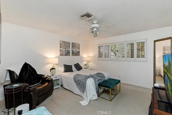 a bedroom with a bed furniture and a flat screen tv