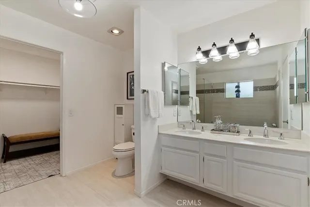 a bathroom with a double vanity sink toilet and shower
