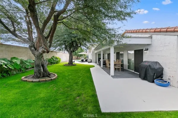 a front view of a house with garden and trees
