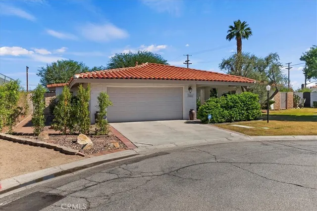 a view of a hallway with potted plants in front of door