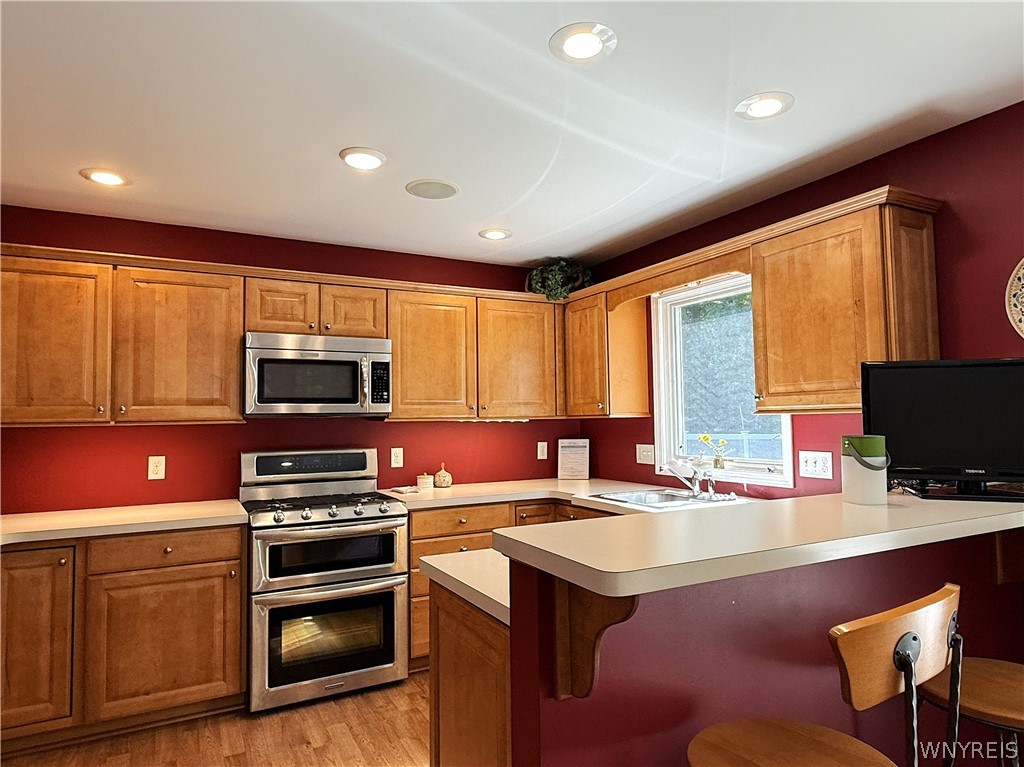 73 Chestnut Lancaster, NY 14086 - Photo 13 of 41 Warm wood cabinetry and recessed lighting define this classic kitchen with a raised breakfast bar.