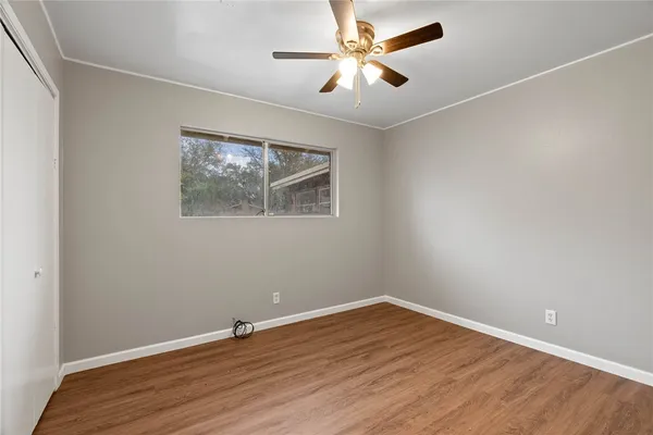 a view of empty room with wooden floor
