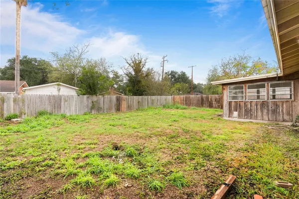 a view of a backyard with barn and wooden fence