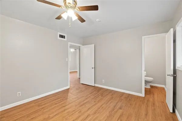 a view of a room with wooden floor and a ceiling fan