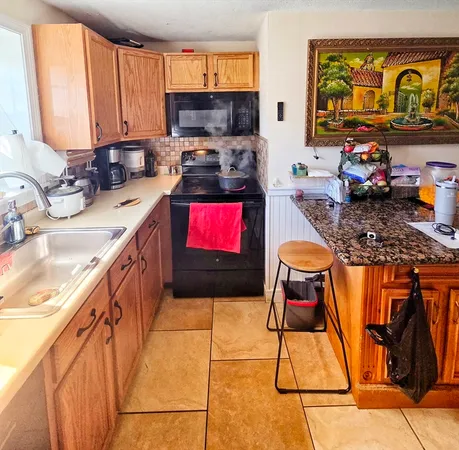 a kitchen with stainless steel appliances granite countertop a stove a sink and a microwave