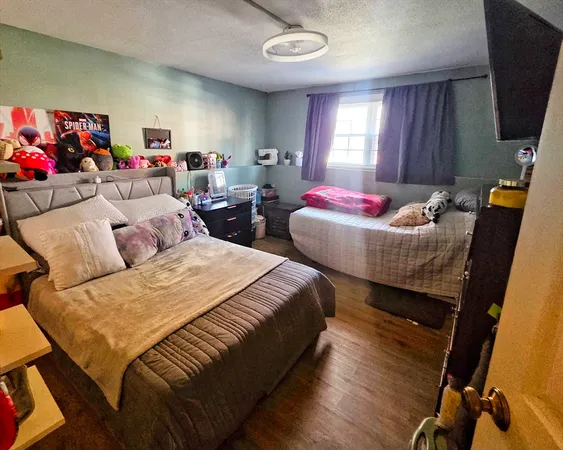 a living room with furniture a flat screen tv and a window