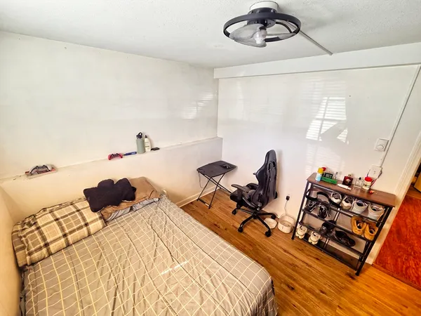 a bedroom with a bed and wooden floor