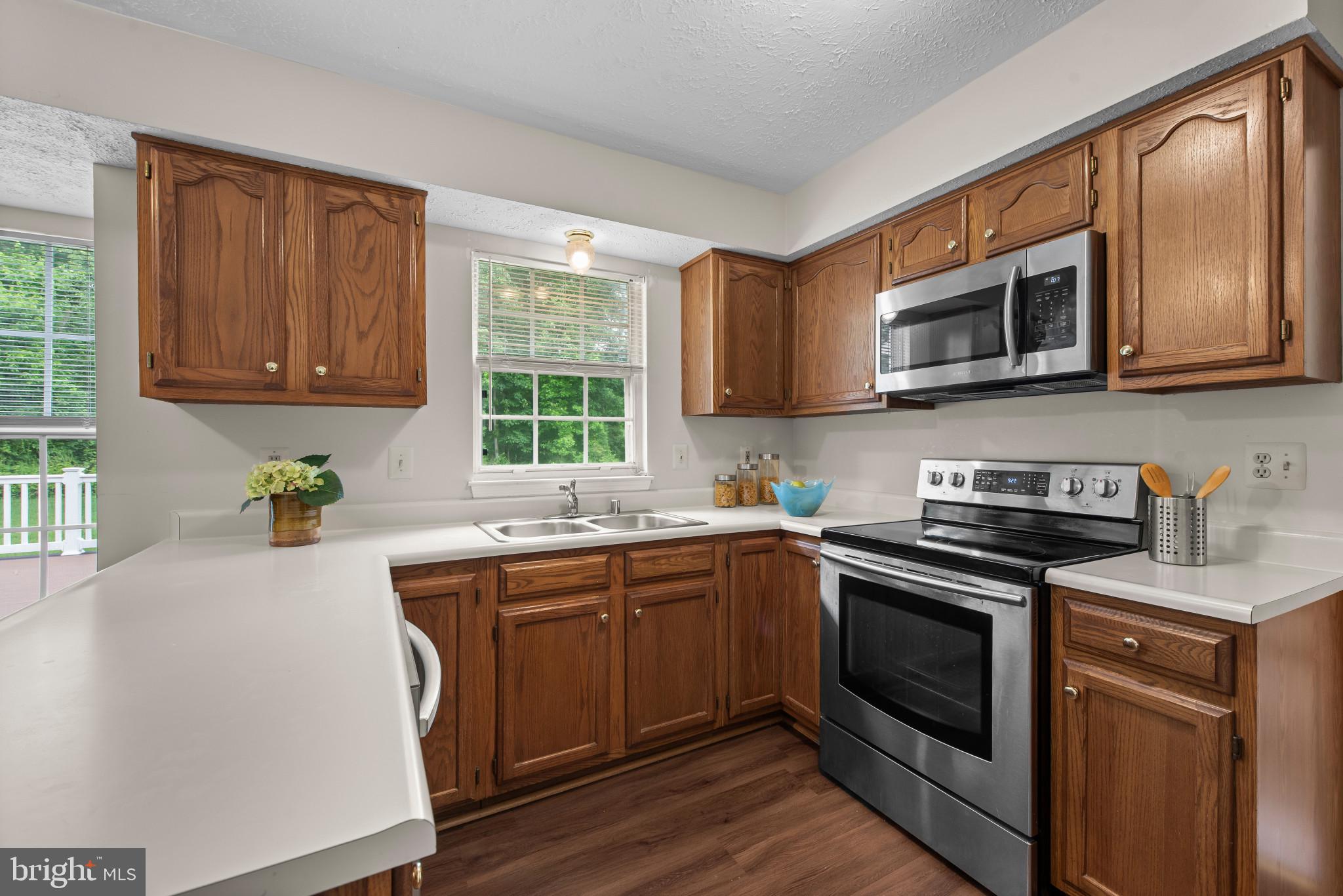 3107 Pouska Road Abingdon, MD 21009 - Photo 10 of 38 a kitchen with stainless steel appliances granite countertop a stove a sink dishwasher and a microwave oven with wooden cabinets