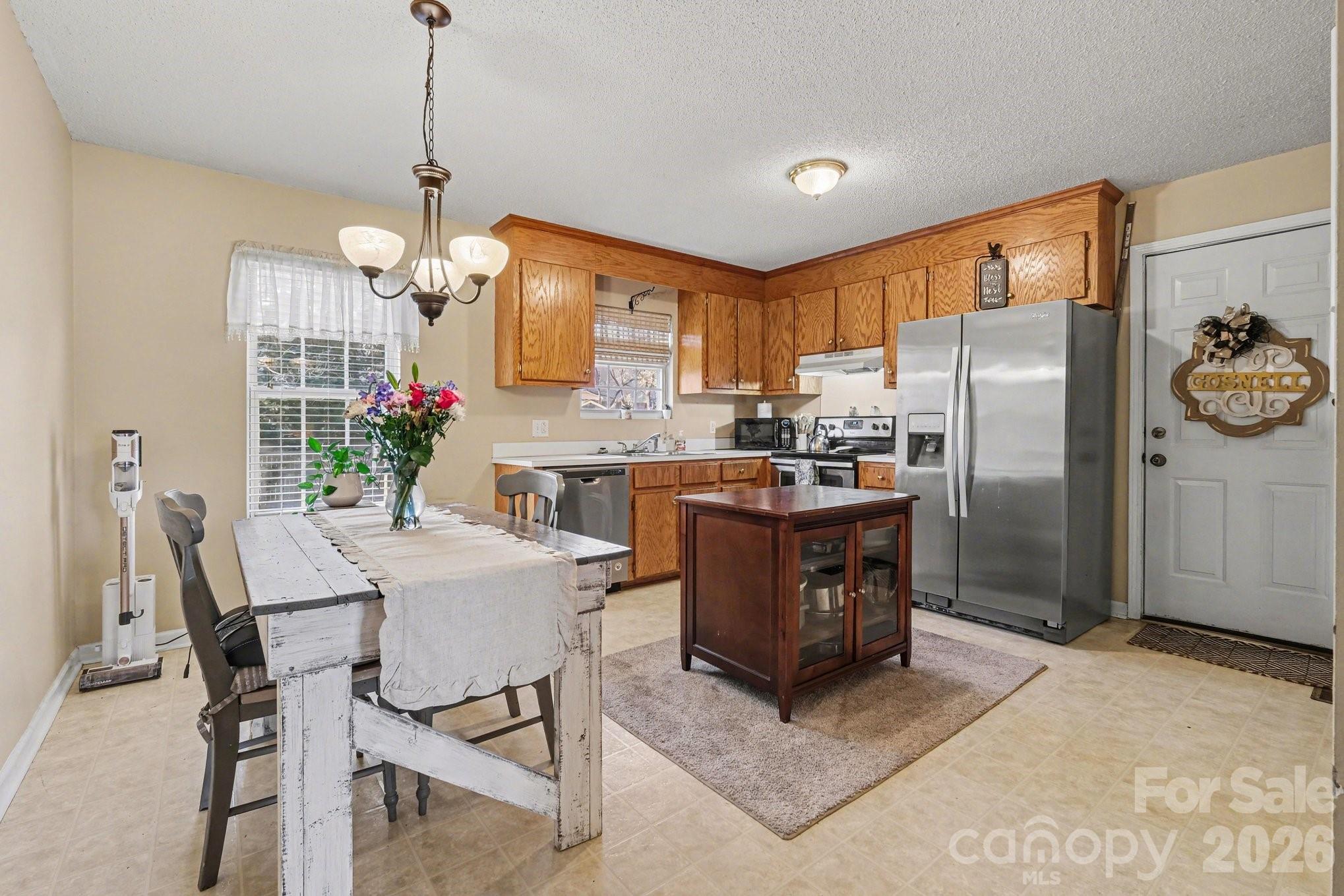 105 Chadwick Circle Dallas, NC 28034 - Photo 9 of 23 a kitchen with stainless steel appliances granite countertop a refrigerator a stove a kitchen island a dining table and chairs