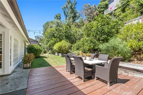 a view of a patio with dining table and chairs with wooden floor and fence