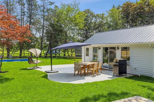 a view of a house with a backyard and a patio