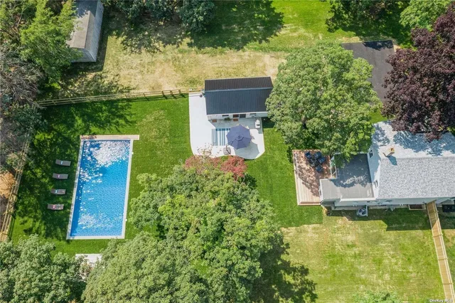 an aerial view of a house with swimming pool outdoor seating and yard