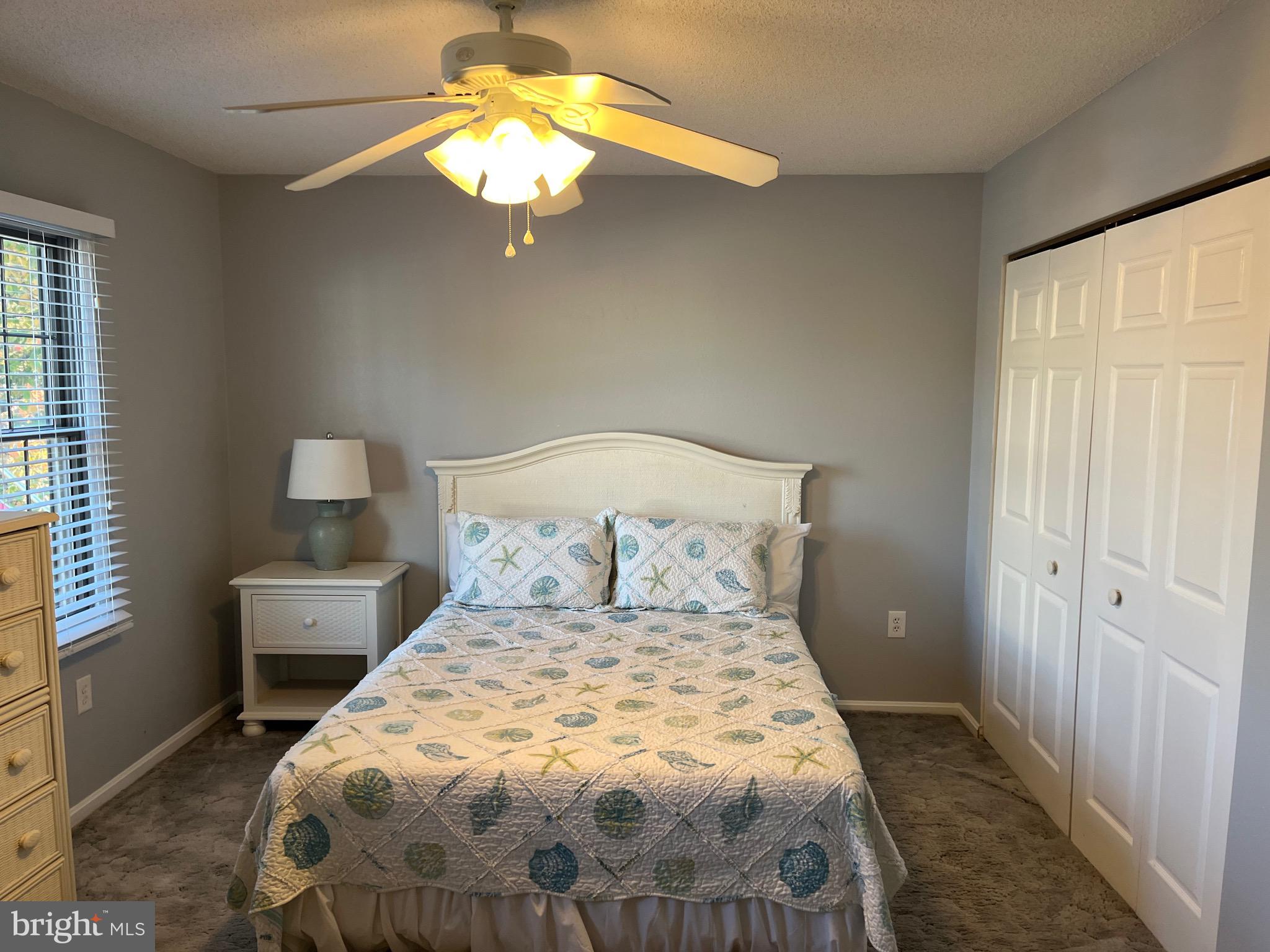 14103 Derrickson Avenue Ocean City, MD 21842 - Photo 12 of 33 a bedroom with a bed and a chandelier