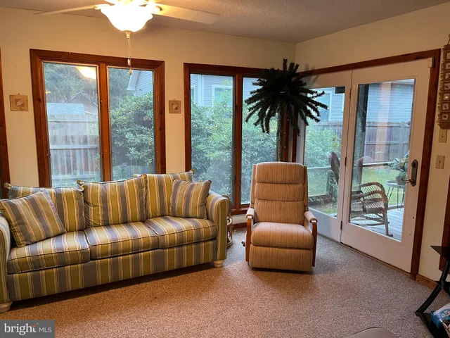 a living room with furniture a chandelier and a window