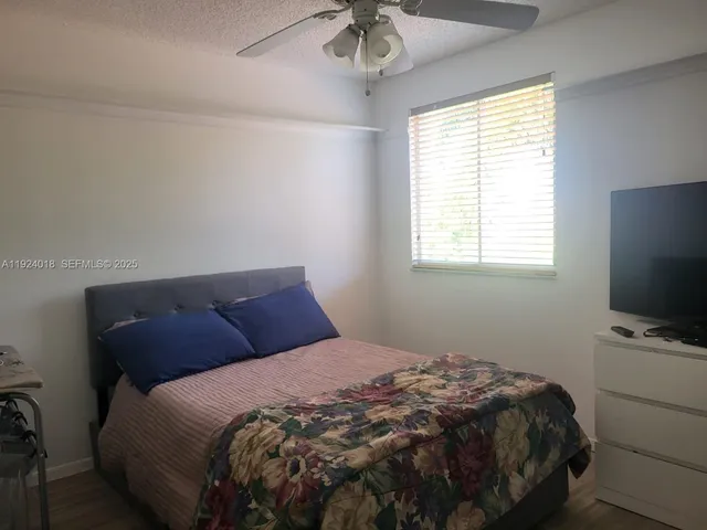 a bedroom with a bed tv and a chandelier
