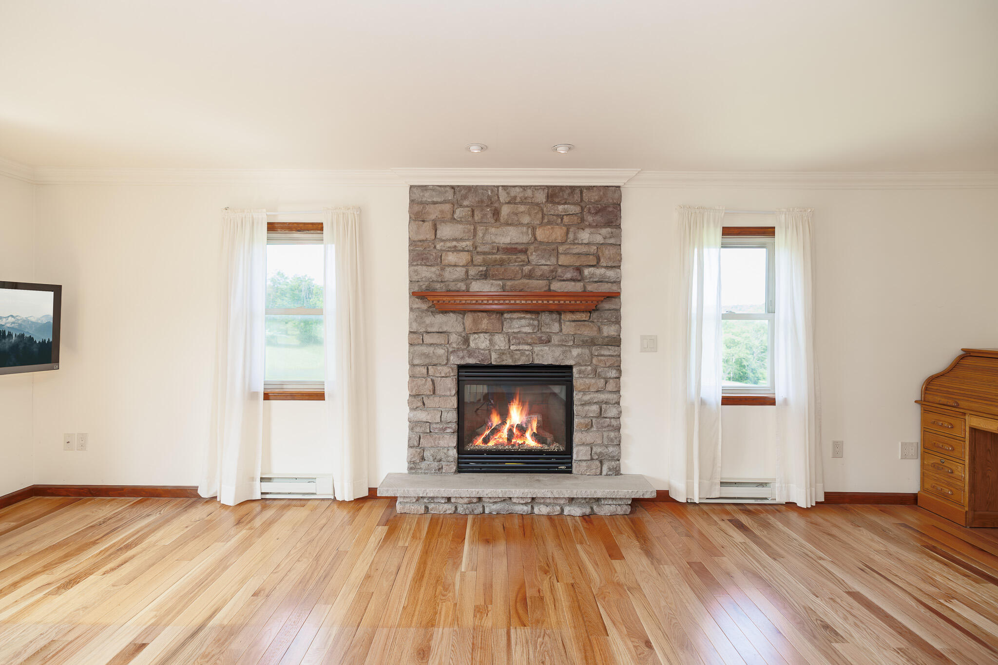 924 Hell Hollow Road Kunkletown, PA 18058 - Photo 32 of 60 an empty room with wooden floor fireplace and windows