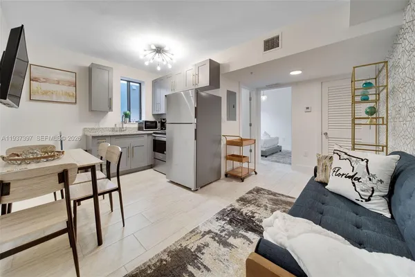 a living room with furniture and kitchen view