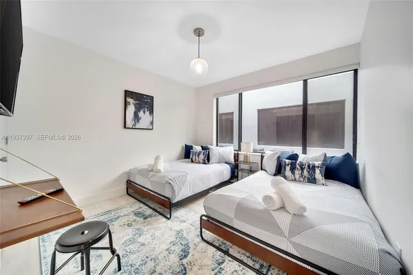 a bedroom with two beds and a large mirror