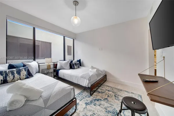 a bedroom with two beds and a flat screen tv