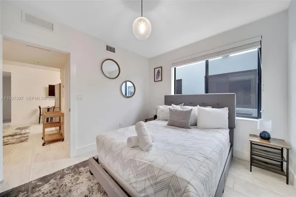 a bedroom with a bed and dresser with mirror