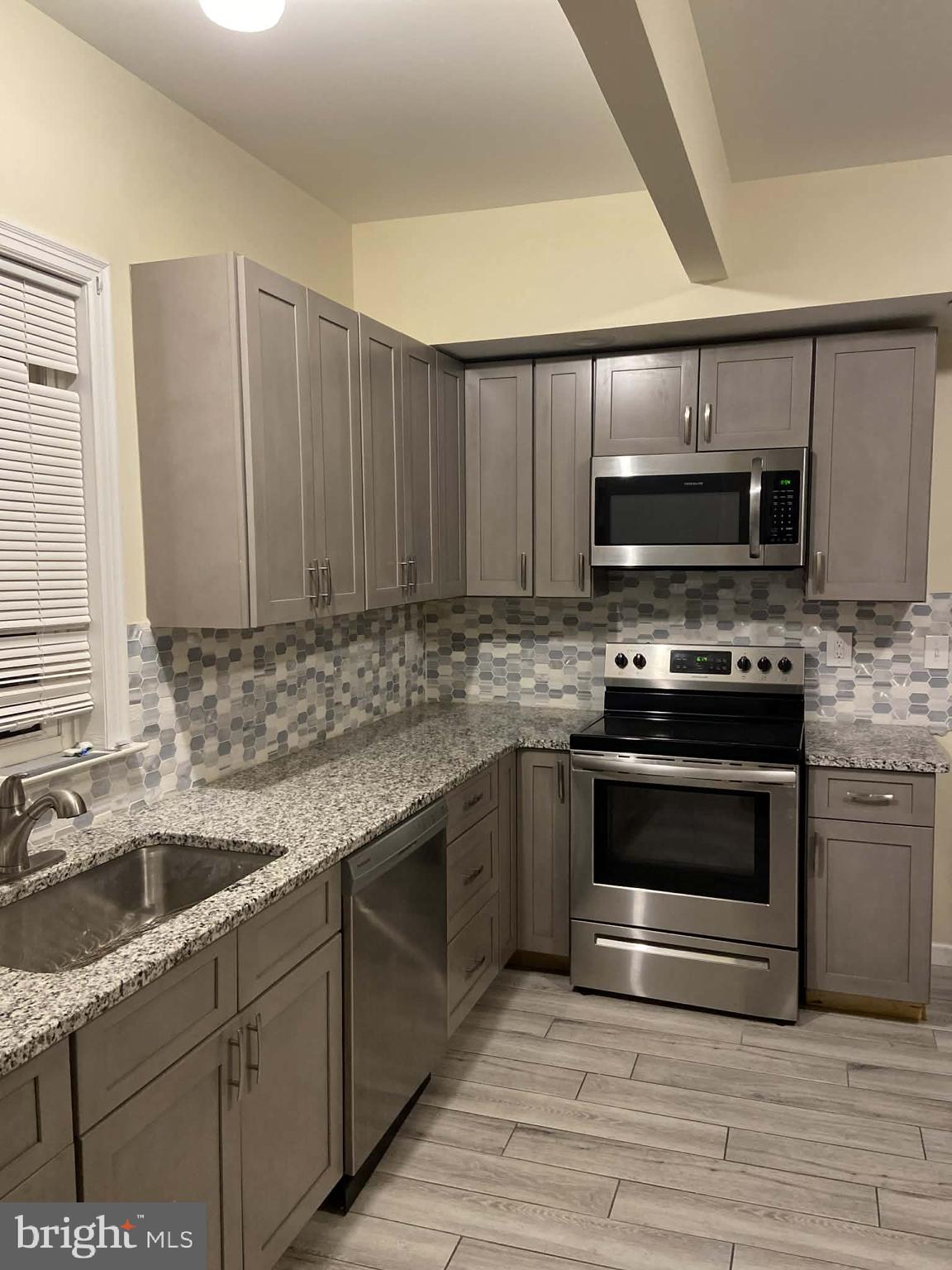 1416 East 5th Street Bethlehem, PA 18015 - Photo 5 of 26 a kitchen with stainless steel appliances granite countertop a sink stove and microwave