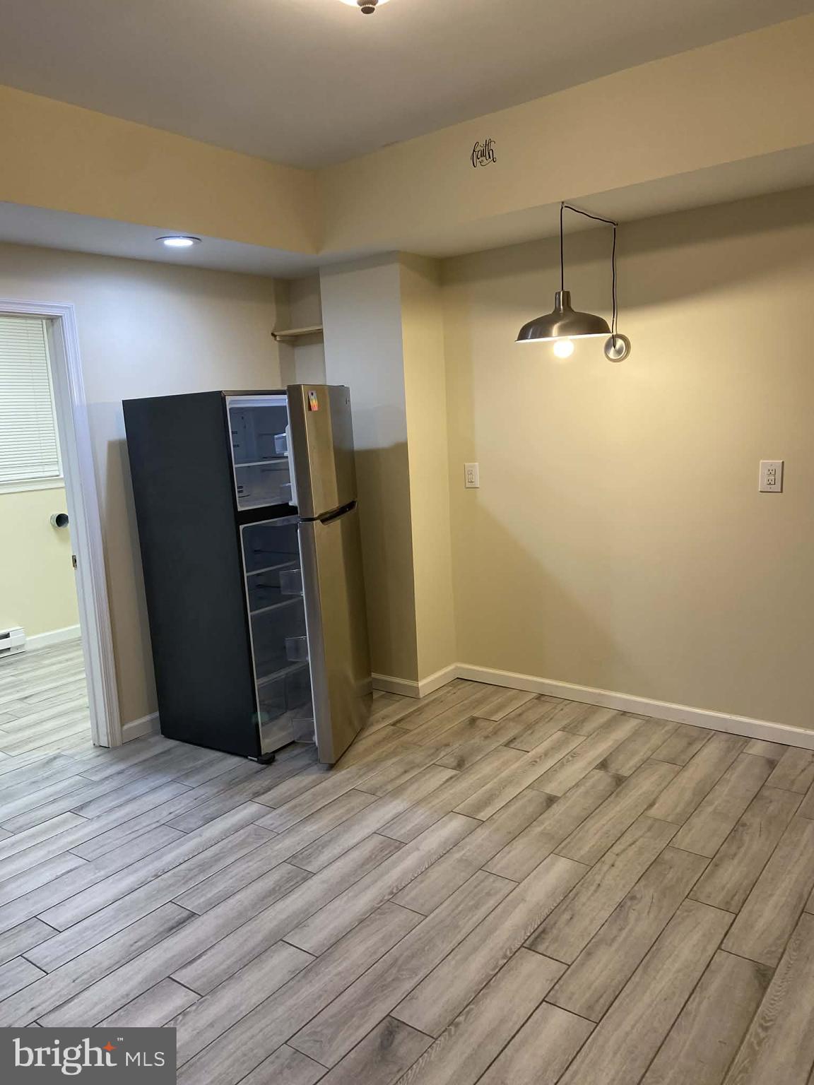 1416 East 5th Street Bethlehem, PA 18015 - Photo 7 of 26 a view of a refrigerator in kitchen and an empty room with wooden floor